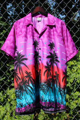 Men's vintage 1990's Island Shirtworks short sleeve button up Hawaiian print shirt in lightweight polyester material in purple, blue, and red with palm trees.