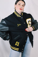 Men's or women's vintage 2000's Settlemein's, Portland, Oregon label long sleeve black varsity letterman jacket with yellow trim.