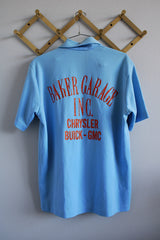 Men's or women's vintage 1970's short sleeve baby blue polyester material polo shirt with half button closure and red glittery wording on the back