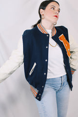 Men's vintage 1960's Skookum Letterman, Centralia Knitting Mills, Centralia Washington label long sleeve navy, white, and orange varsity letterman jacket in wool and leather material.