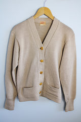 Women's vintage 1960's A Genuine Dehen, The Buddy label long sleeve light tan colored button up cardigan sweater. Ribbed texture cuffs and two front pockets.