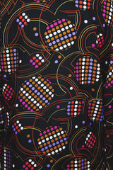 Women's vintage 1970's long sleeve button up blouse in black with all over multi-colored abstract print in a lightweight polyester material.