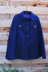 Women's vintage 1960's navy blue wool material poncho with slits for arms, gold hardware and gold buttons. Fully lined.