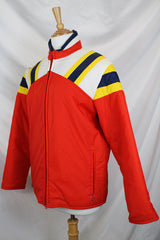 Men's or women's vintage 1980's JCPenney, Made in Hong Kong label long sleeve zip up puffy jacket in nylon material and red, blue, white, and yellow colors.