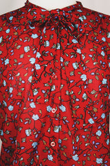 Women's vintage 1970's Donnkenny label long sleeve button up blouse with an attached tie neck. Red with all over blue ditsy floral print.