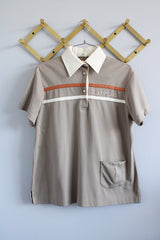 Women's vintage 1970's King Louie Creation, Made in USA label short sleeve polyester material polo top in light beige with cream and orange trim.