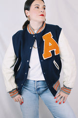 Men's vintage 1960's Skookum Letterman, Centralia Knitting Mills, Centralia Washington label long sleeve navy, white, and orange varsity letterman jacket in wool and leather material.