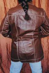 Women's or men 's vintage 1970's Montgomery Ward label long sleeve chocolate brown colored leather jacket with contrast stitching and popper buttons.