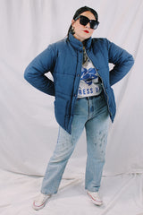 Men's or women's vintage 1980's long sleeve navy blue puffer jacket with zipper, popper buttons, and pockets. Cotton and polyester materials.