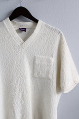 Women's or men's vintage 1970's Joel, Cal Made label short sleeve white top with a V shaped neckline and a chest pocket in textured acrylic material.