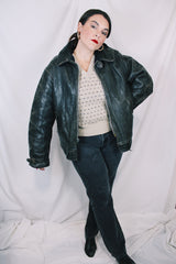 Men's vintage unknown, maybe around 40's-50's long sleeve black distressed leather jacket with zipper front closure and buckles on cuffs.