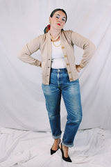 Women's vintage 1960's A Genuine Dehen, The Buddy label long sleeve light tan colored button up cardigan sweater. Ribbed texture cuffs and two front pockets.