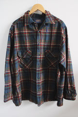 Men's vintage 1970's Pendleton label long sleeve wool button up shirt in size XL. Blue and red plaid all over print. Two chest pockets.