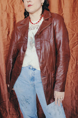 Women's or men's vintage 1970's chocolate brown colored leather jacket with leather buttons and double lapel.