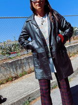 long sleeve black long leather jacket, collar and buttons up the front vintage 1960's