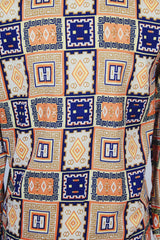 Men's vintage 1970's Envoy label long sleeve button up shirt with dagger collar with all over orange and navy abstract print.