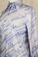 Women's vintage 1970's Devon long sleeve button up blouse with a dagger collar. Light purple color with all over ditsy floral print.