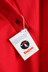 Women's vintage 1970's King Louie Creation, Made in USA label short sleeve red bowling top with half button closure, collar, and a pocket in polyester.