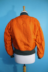 Women's or men's vintage army bomber jacket. Cropped and reversible in a Nylon material. One side is army green and one side in orange.
