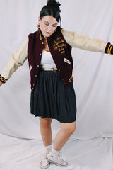Women's or men's vintage 1982 Nelson's Jackets, Portland, Oregon label long sleeve letterman jacket with a maroon wool body and cream colored leather arms. Yellow stripped trim and popper buttons. Embroidery on chest.