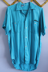 Men's or women's vintage 1970's The Swingster label short sleeve bright blue button up bowling shirt with chest pockets and name embroidered near pocket.