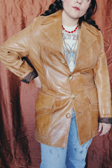 Women's or men's vintage 1970's Lou Pollack, Made in Spain label long sleeve long length tan camel brown colored leather blazer jacket with tortoise buttons up the front.