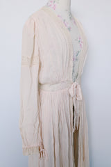 Women's vintage long sleeve long length pale pink sheer robe with an open tie front and lace trim. Has small shoulder pads and ties on cuffs.