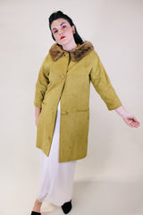 Women's vintage 1960's long sleeve long length button up suede coat with fur trim on collar. Mustard yellow color. Has pockets and side slits.