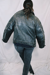 Men's vintage unknown, maybe around 40's-50's long sleeve black distressed leather jacket with zipper front closure and buckles on cuffs.
