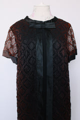 Women's vintage 1960's short sleeve mini length black dress with lace overlay and ribbon trim and bow. Zipper in the back.
