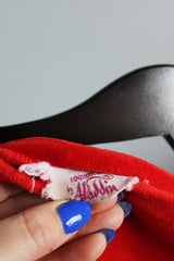 Women's vintage 1970's Aladdin label short sleeve red velour cape top with tasseled trim and holes for arms.