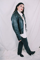 Men's or women's vintage 1980's long sleeve black leather motorcycle jacket with silver hardware. Zipper front closure and pockets.