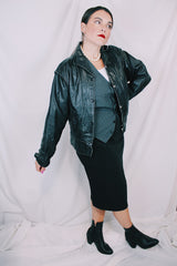 Women's vintage 1980's long sleeve black leather lightweight jacket. Dolman fit and snap buttons.