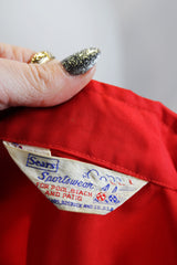 Men's or women's vintage 1970's Sears Sportswear, For Pool Beach and Patio label long sleeve red nylon windbreaker jacket with two white stripes in the front.