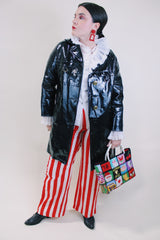 Women's vintage 1960's long sleeve black vinyl material jacket with gold buttons and hardware. Fully lined and has two side pockets.