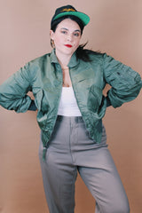 Men's vintage 1980's Flyer's CWU Military Flyer's Jacket, Made in USA label size medium long sleeve cropped length army green zip up bomber jacket with orange liner.