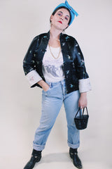 Women's vintage 1960's satin reversible robe jacket in black and grey with all over embroidered print. Mandarin collar and fabric buttons.