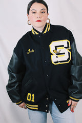 Men's or women's vintage 2000's Settlemein's, Portland, Oregon label long sleeve black varsity letterman jacket with yellow trim.