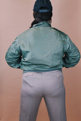 Men's vintage 1980's Flyer's CWU Military Flyer's Jacket, Made in USA label size medium long sleeve cropped length army green zip up bomber jacket with orange liner.