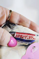 Women's vintage 1970's Pykettes label long sleeve floral printed tunic blouse with keyhole cut out front closure in grey, orange, and cream colors.