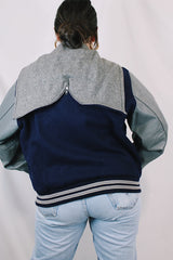 Men's or women's vintage 1980's Settlemein's, Portland, Oregon label long sleeve navy and grey varsity letterman jacket in wool, leather, and nylon. Snap buttons and hood.