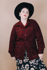 Women's or men'd vintage 1970's size medium long sleeve maroon color button up lightweight western style jacket with pockets and contrast stitching.