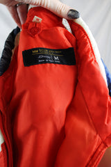 Men's or women's vintage 1980's JCPenney, Made in Hong Kong label long sleeve zip up puffy jacket in nylon material and red, blue, white, and yellow colors.