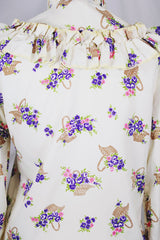 Women's vintage 1980's Val Lanne's label long sleeve button up blouse with ruffle details and pearl buttons. Cream color with all over purple floral print.