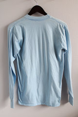 Men's or women's vintage 1980's Touch of Gold, Made in USA label long sleeve light blue t-shirt with red text on front that reads Texas in a polyester and cotton material.