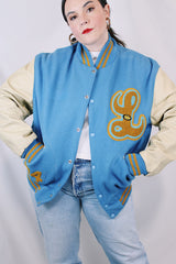 Men's or women's vintage 1994 Settlemien's, Portland, Oregon label long sleeve baby blue and cream varsity letterman jacket with yellow trim in leather and wool material.