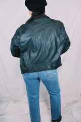 Men's or women's vintage 1980's long sleeve black leather moto jacket with all over silver hardware. Snap buttons, pockets with zippers, and zipper closure.