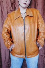 Women's or men's vintage 1970's Adler Leather MFG. CO., Made in California label long sleeve burnt orange leather jacket that zips up the front with side pockets and dagger collar.