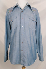 Men's vintage 1970's long sleeve chambray denim shirt with colored embroidery in the front and back.