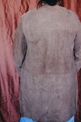 Women's vintage 1960's long length long sleeve tan brown colored suede jacket. No collar and suede buttons up the front.